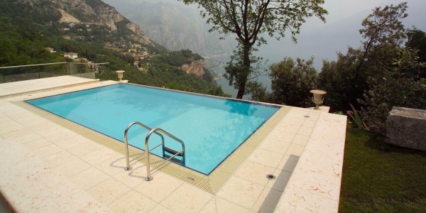 Piscina interrata con sfioro a cascata, rettangolare su terrazza.