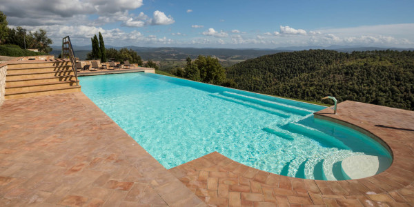 Piscina interrata con sfioro a cascata, rettangolare su terrazza.