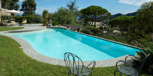 Piscina a forma libera con sfioro a Cascata su terrazzamento.