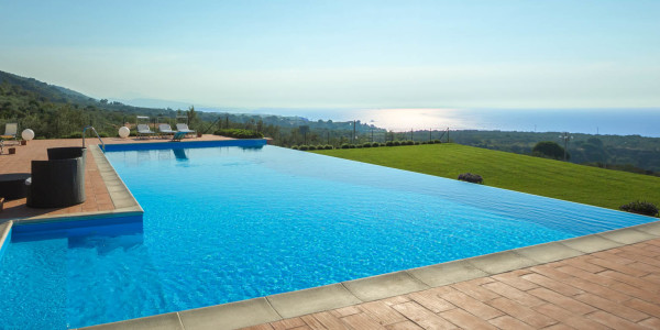 Piscina su terrazzamento con sfioro a Cascata e gradini.