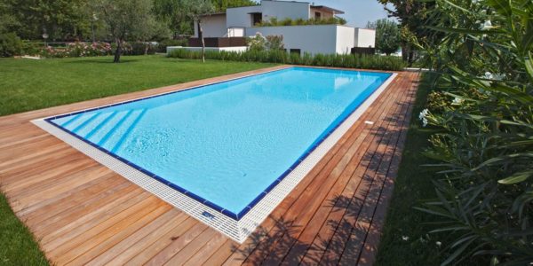 Piscina interrata esterna a sfioro in giardino.