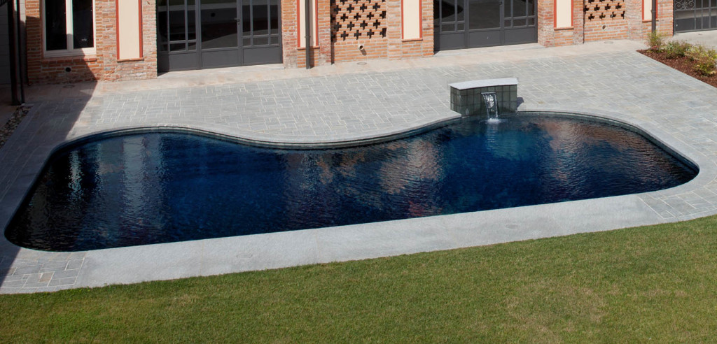 Piscina interrata esterna con bordo a sfioro nascosto Freedom e fontana, a forma libera.