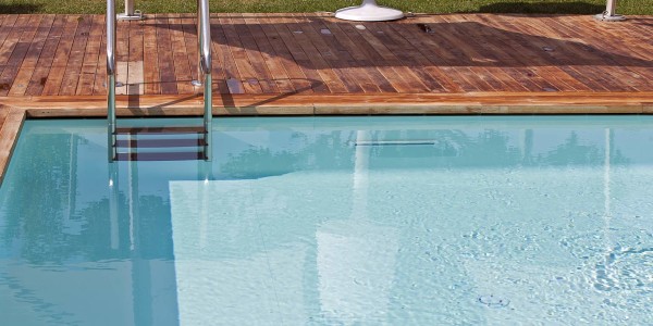 Piscina interrata esterna con bordo a sfioro nascosto Freedom e bordo in legno.