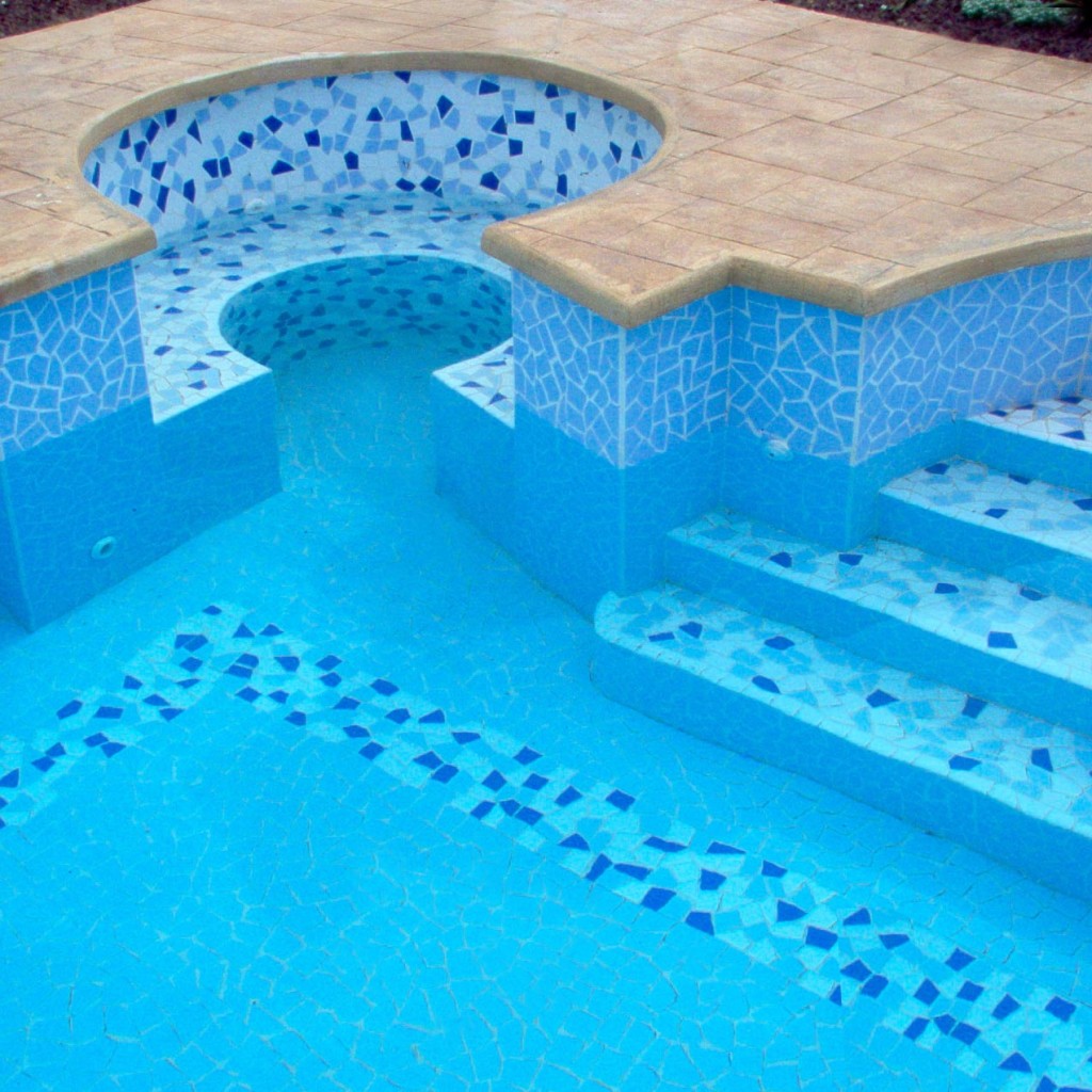 Piscina interrata con mosaico, scale e seduta.