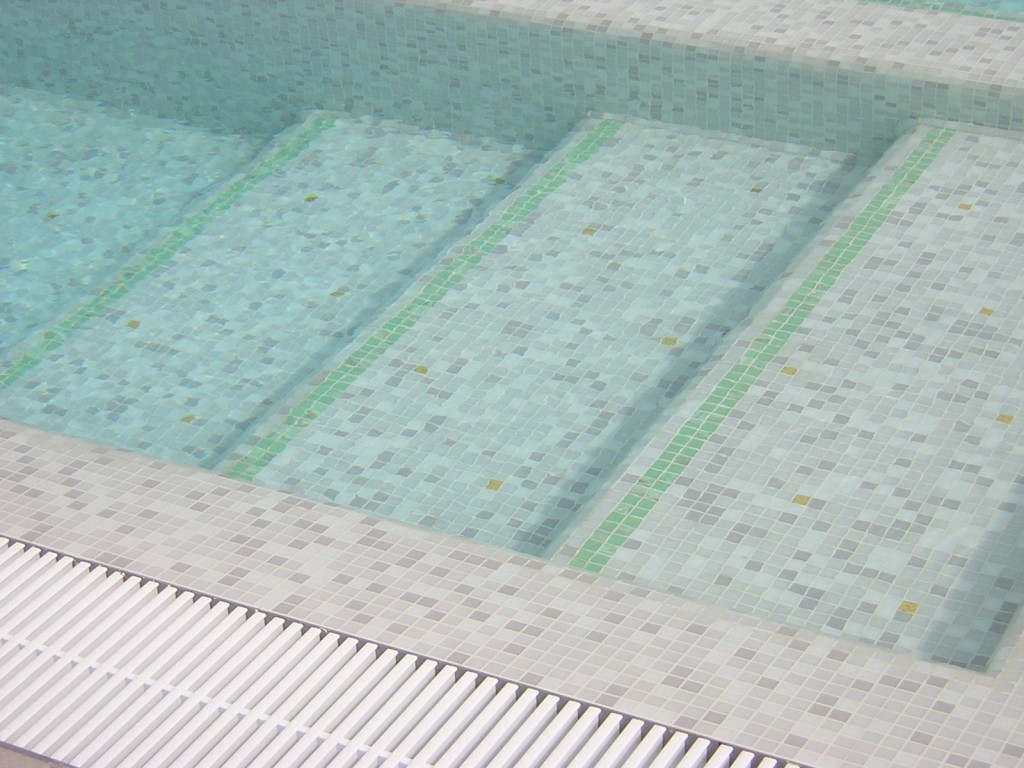 Piscina interrata con mosaico e scale.